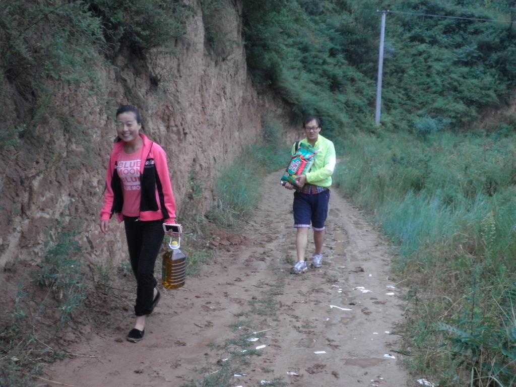 在泥泞的山路上冒雨前往学生家庭